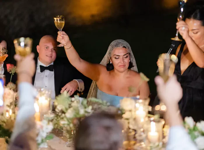 The bride rising her glass for a collective toast