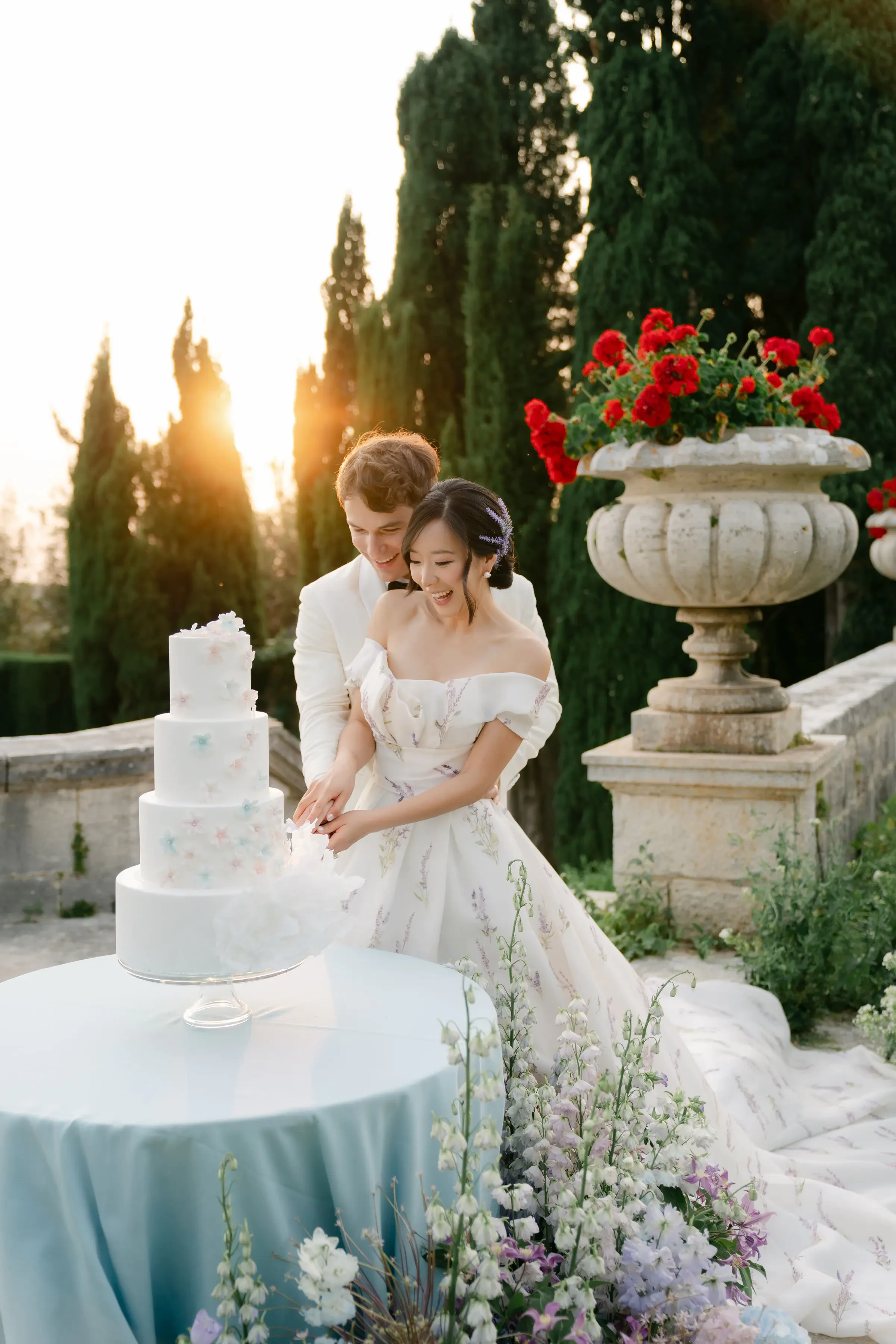Bride And Groom Cutting Wedding Cake Outdoors