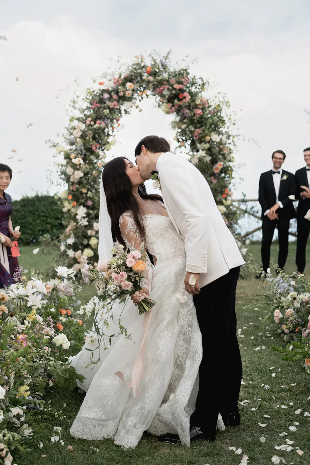 Bride and Groom kissing in front of the wedding arch in villa cimbrone in Ravello